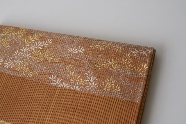 Traditional Kyoto gold-thread brocade (nishiki) with woven floral motifs — the heritage that inspired Nishikiito