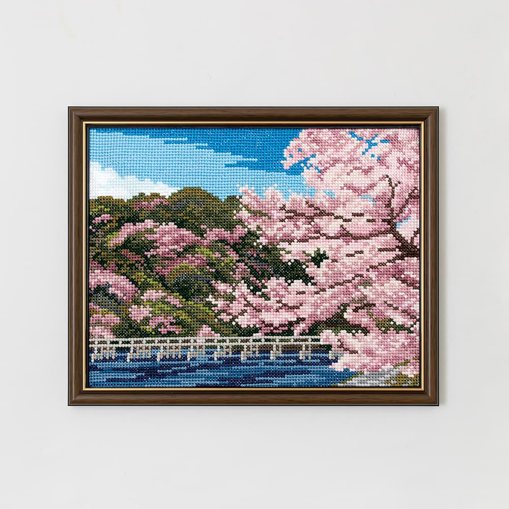 Framed COSMO embroidery of cherry blossoms and a bridge over water in spring