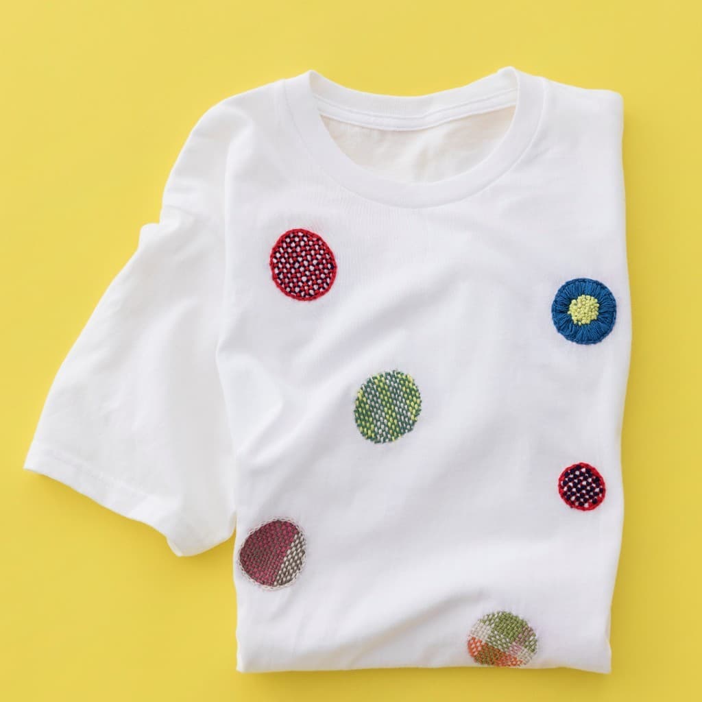 Colorful sashiko mending on a folded T-shirt