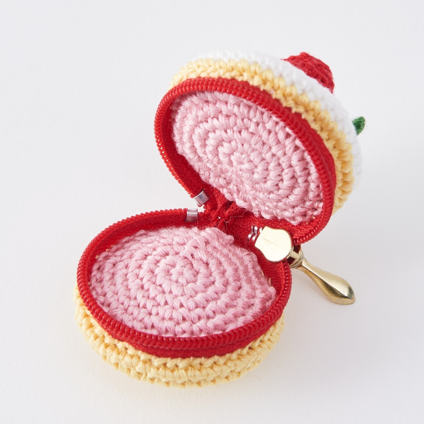Open strawberry-cake pouch crocheted with COSMO embroidery floss, pink lining and red zipper visible
