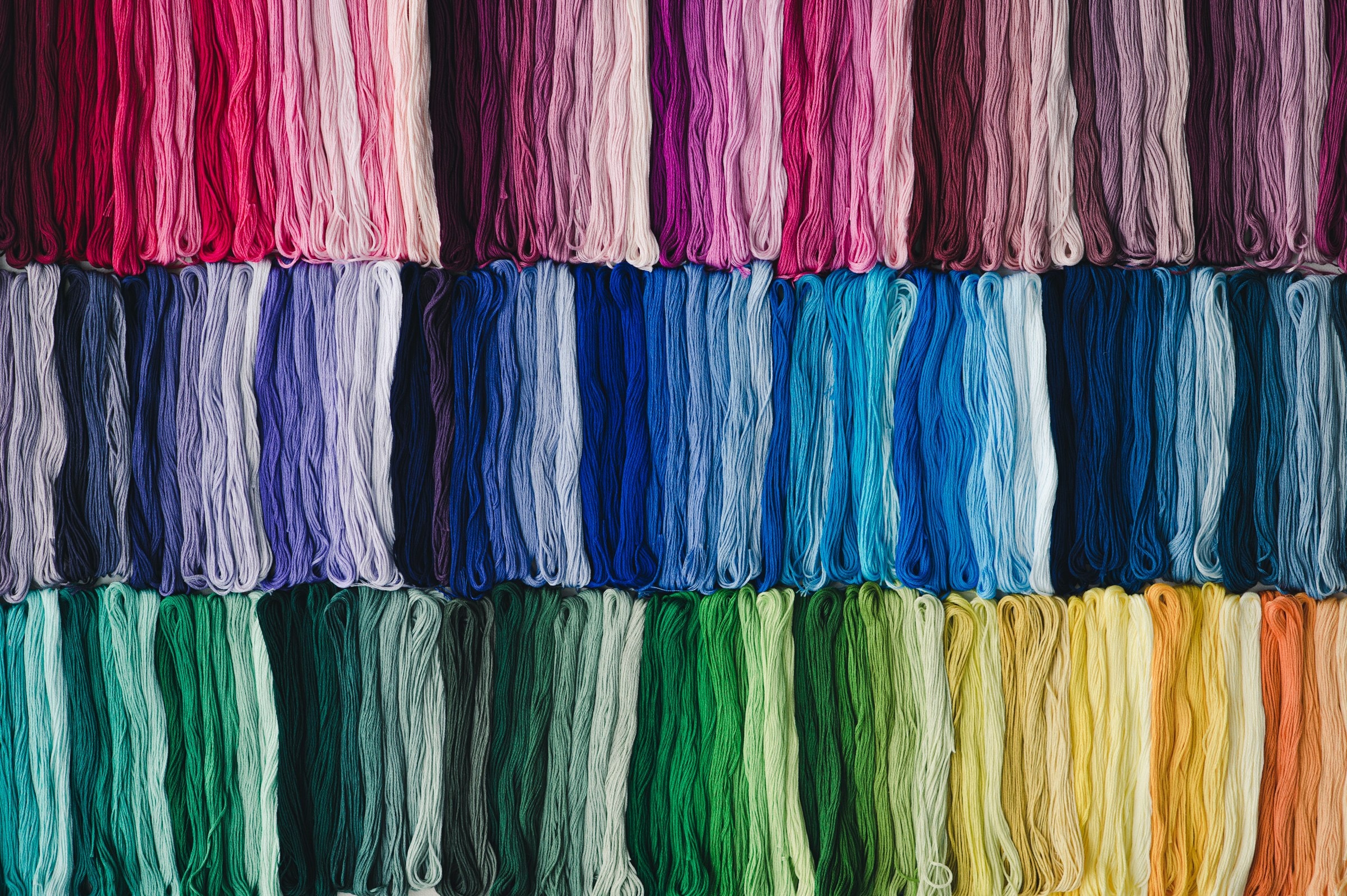 A wide arrangement of COSMO No. 25 embroidery floss skeins across over 500 solid colors
