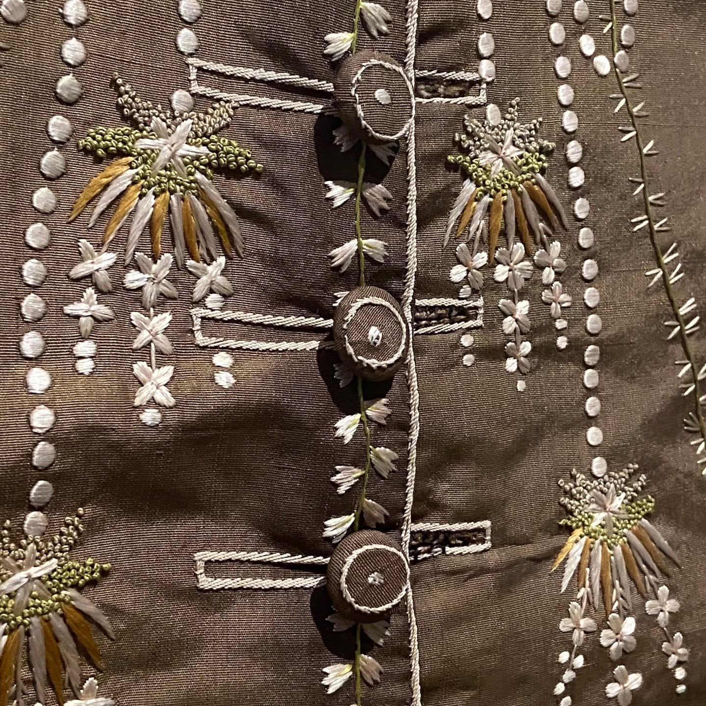 Dark chocolate brown silk with white and gold floral embroidery, fabric-covered buttons, and vertical French-knot columns