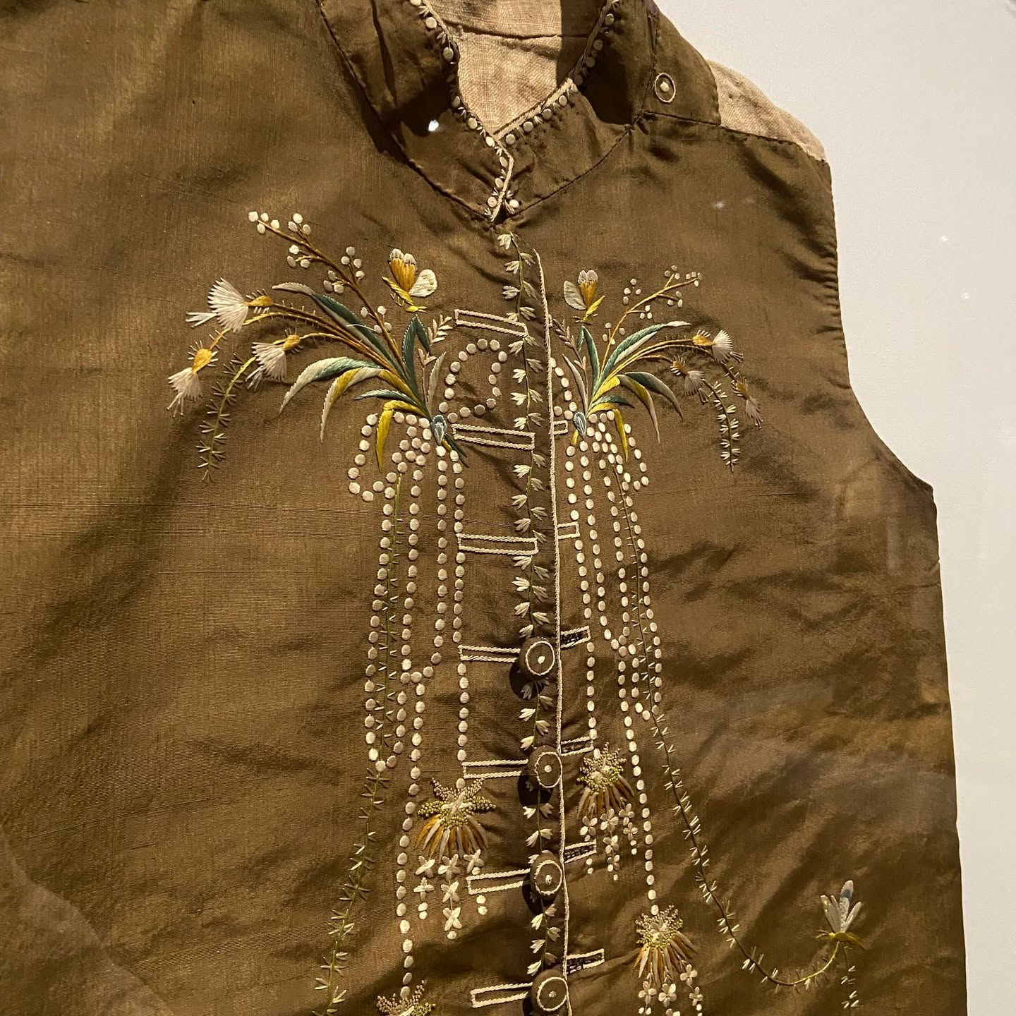 Olive-bronze silk waistcoat with cream and yellow botanical sprays and cascading white French-knot trails
