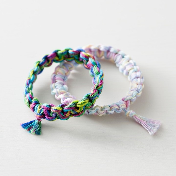 Two variegated braided floss bracelets—bright multi and soft pastel—with tassels