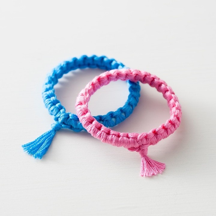 Bright pink and sky-blue solid braided floss bracelets with small tassels