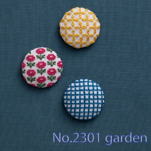 Close view of embroidered button covers with small floral and chevron patterns