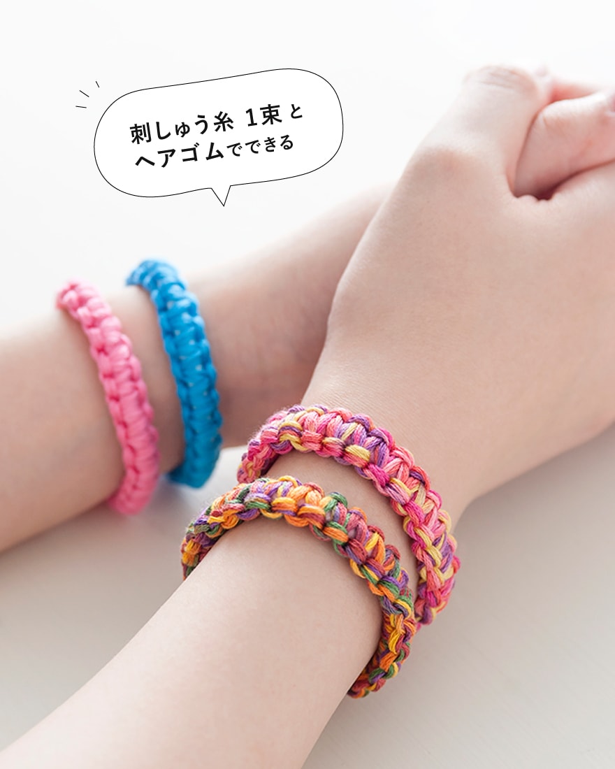 Wrist with braided embroidery-floss bracelets; Japanese tip about one skein and a hair tie