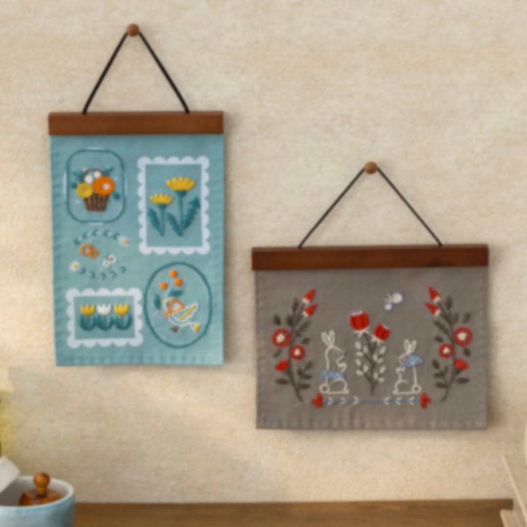 Blue stamp-panel hanging beside gray rabbit folk hanging