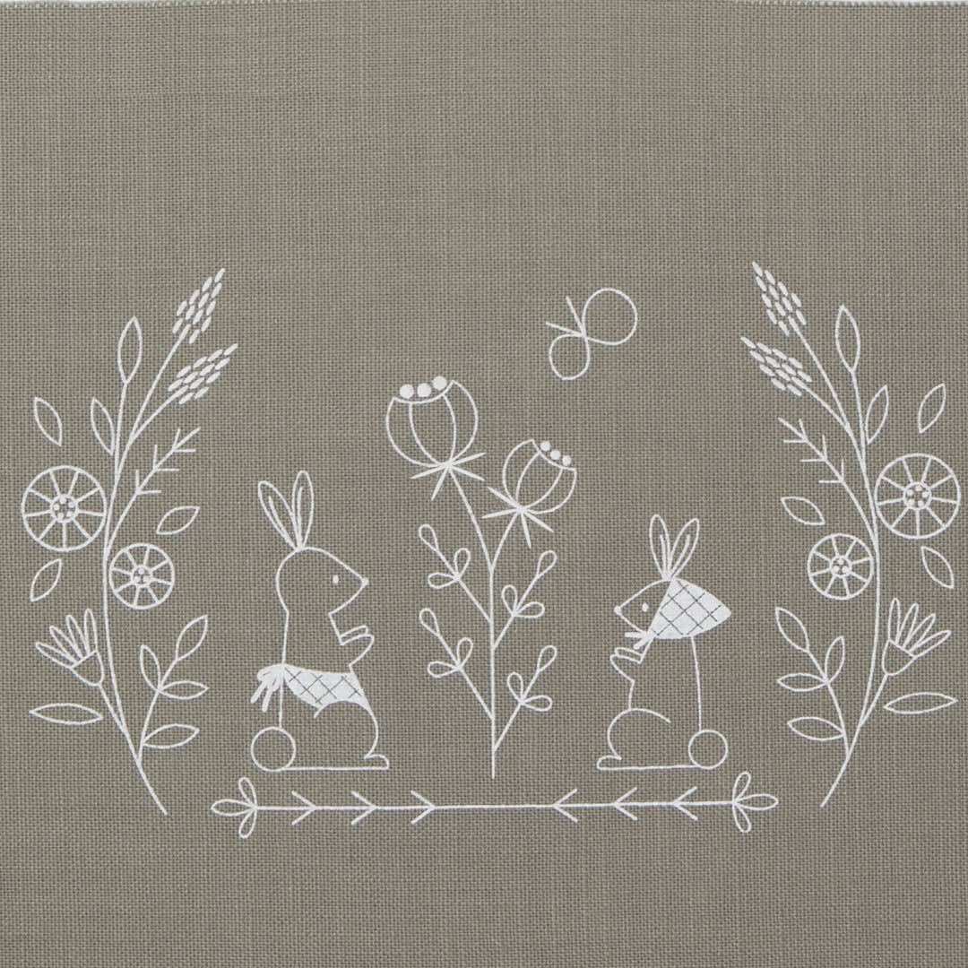 White line embroidery of rabbits and botanical sprigs on medium grey fabric