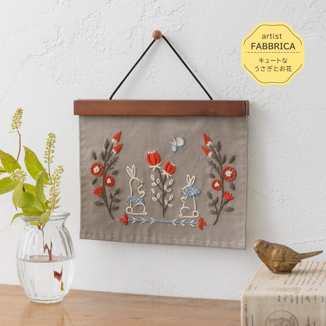 Taupe hanging with two white rabbits among red flowers on a wooden magnetic bar