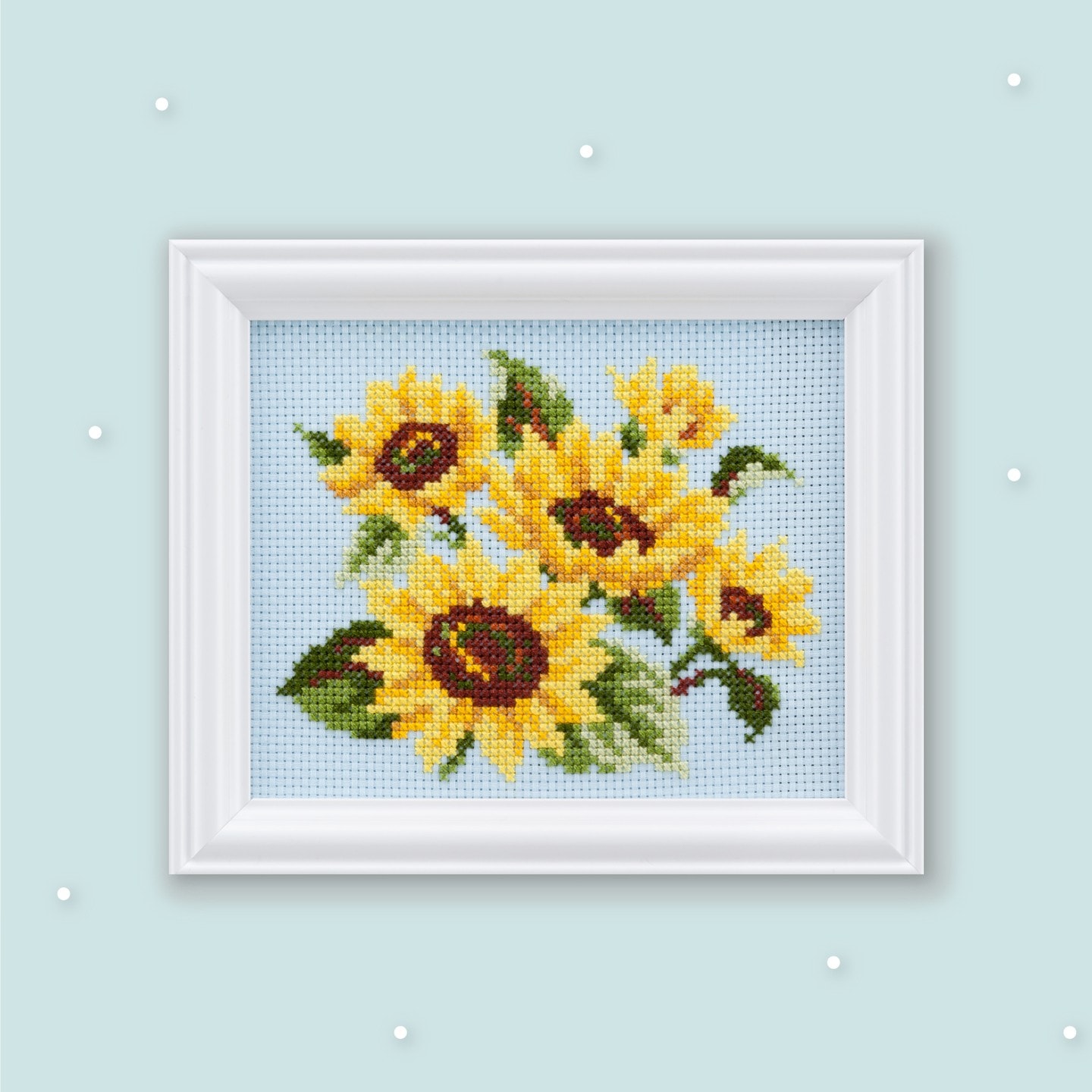 Framed sunflower bouquet cross-stitch on light blue Aida