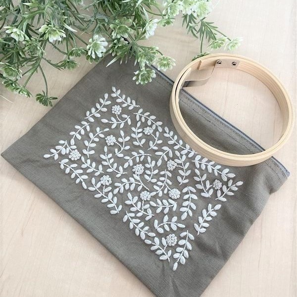 Gray zippered pouch with white botanical vine embroidery