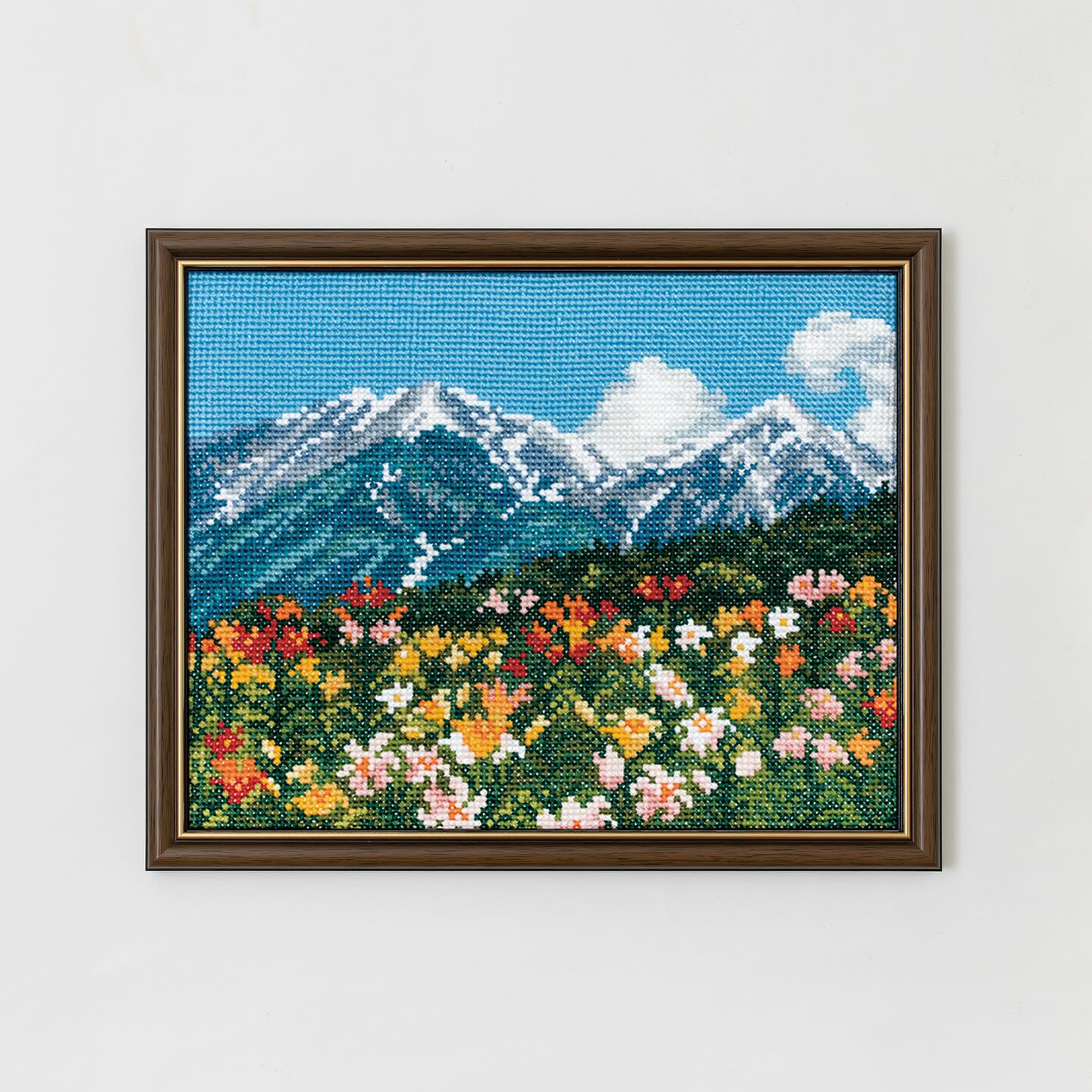 Landscape embroidery of alpine wildflowers under open summer sky