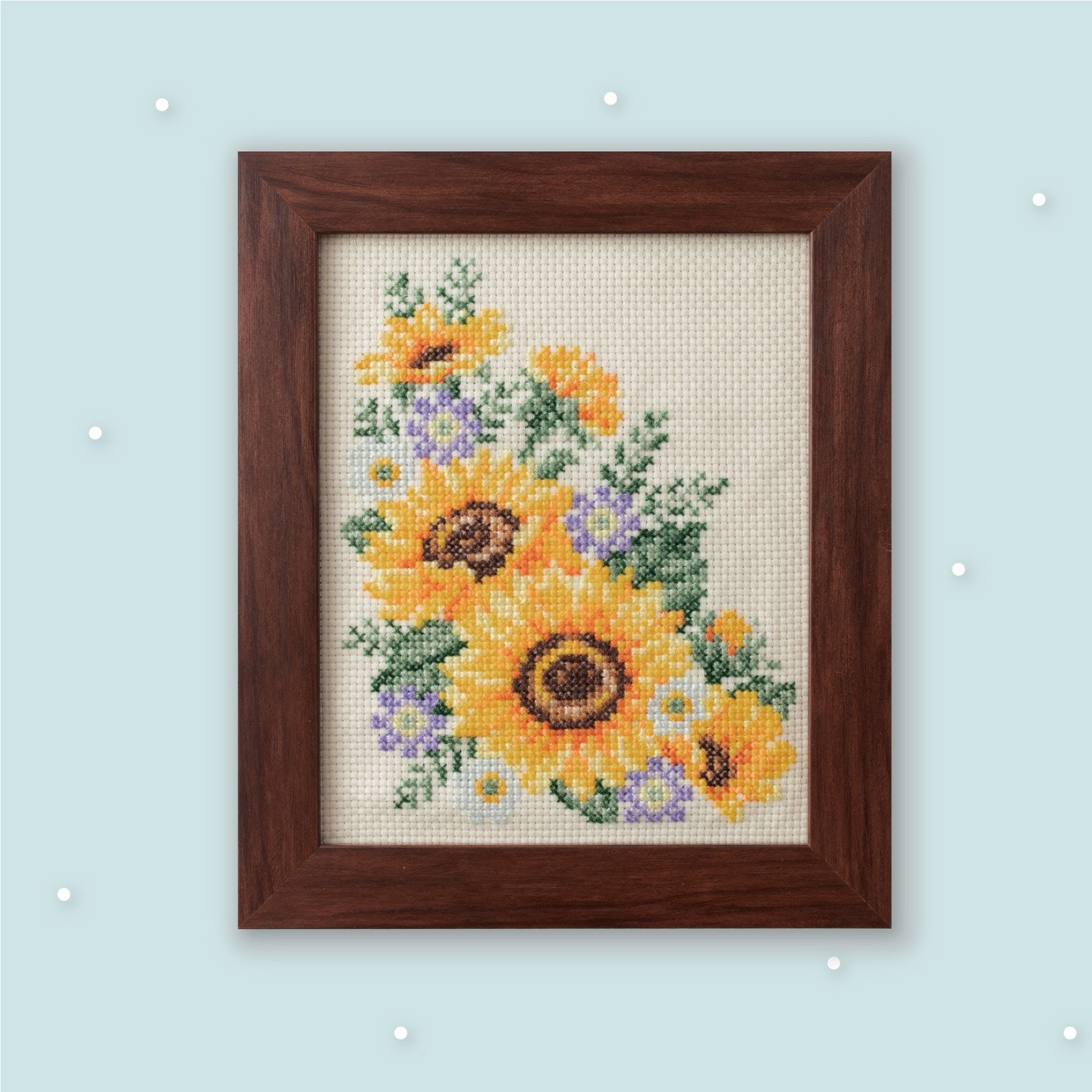 Framed cross-stitch bouquet of bright yellow sunflowers with purple accents