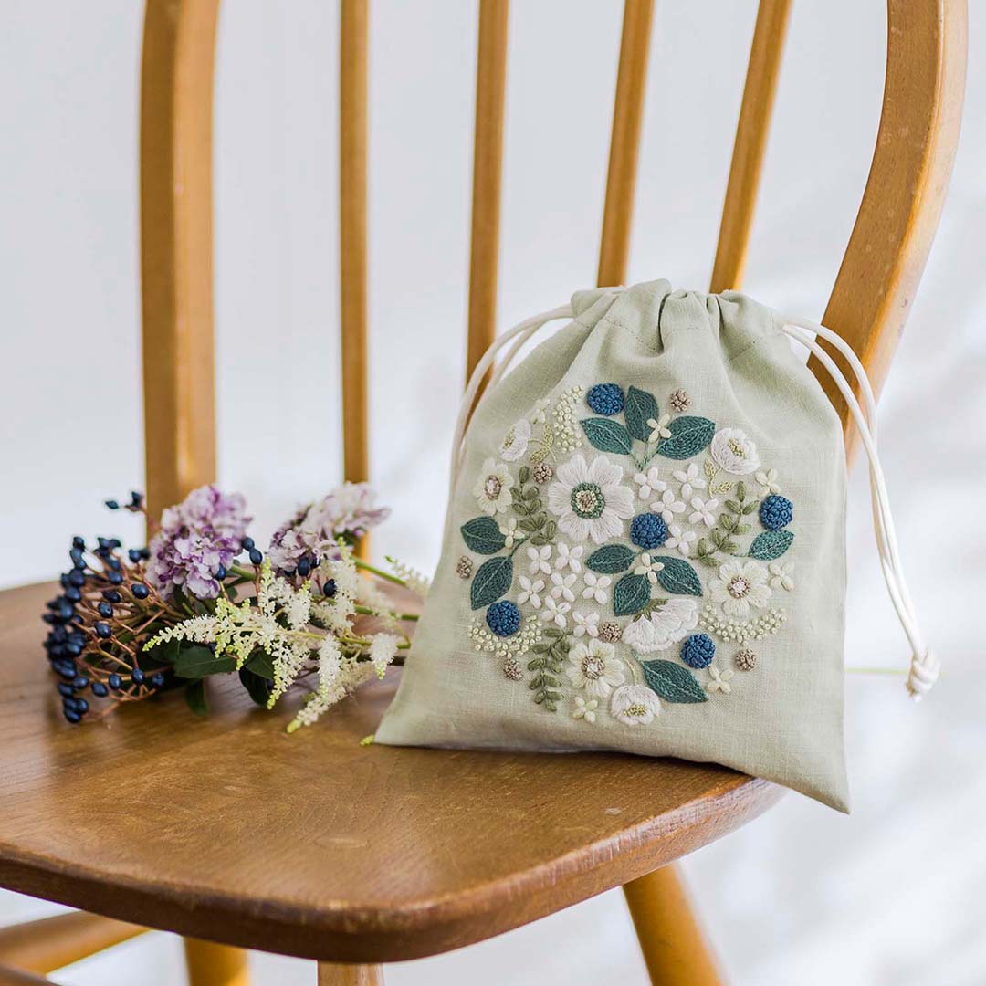 Sage linen drawstring pouch with circular white-flower embroidery