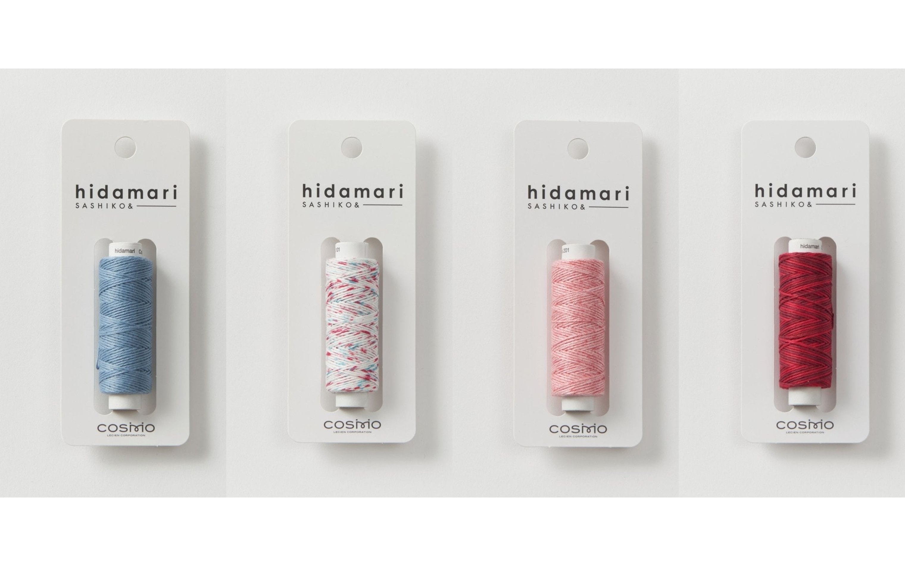 A lineup of cone-wound COSMO hidamari sashiko thread packs in solid, speckled, and heather colors