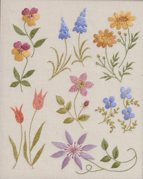 Colorful floral embroidery with satin and stem stitches on cream fabric