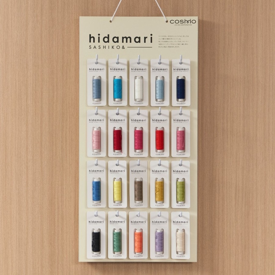 Display board of hidamari solid-color sashiko thread cones in blues, reds, pinks, and greens