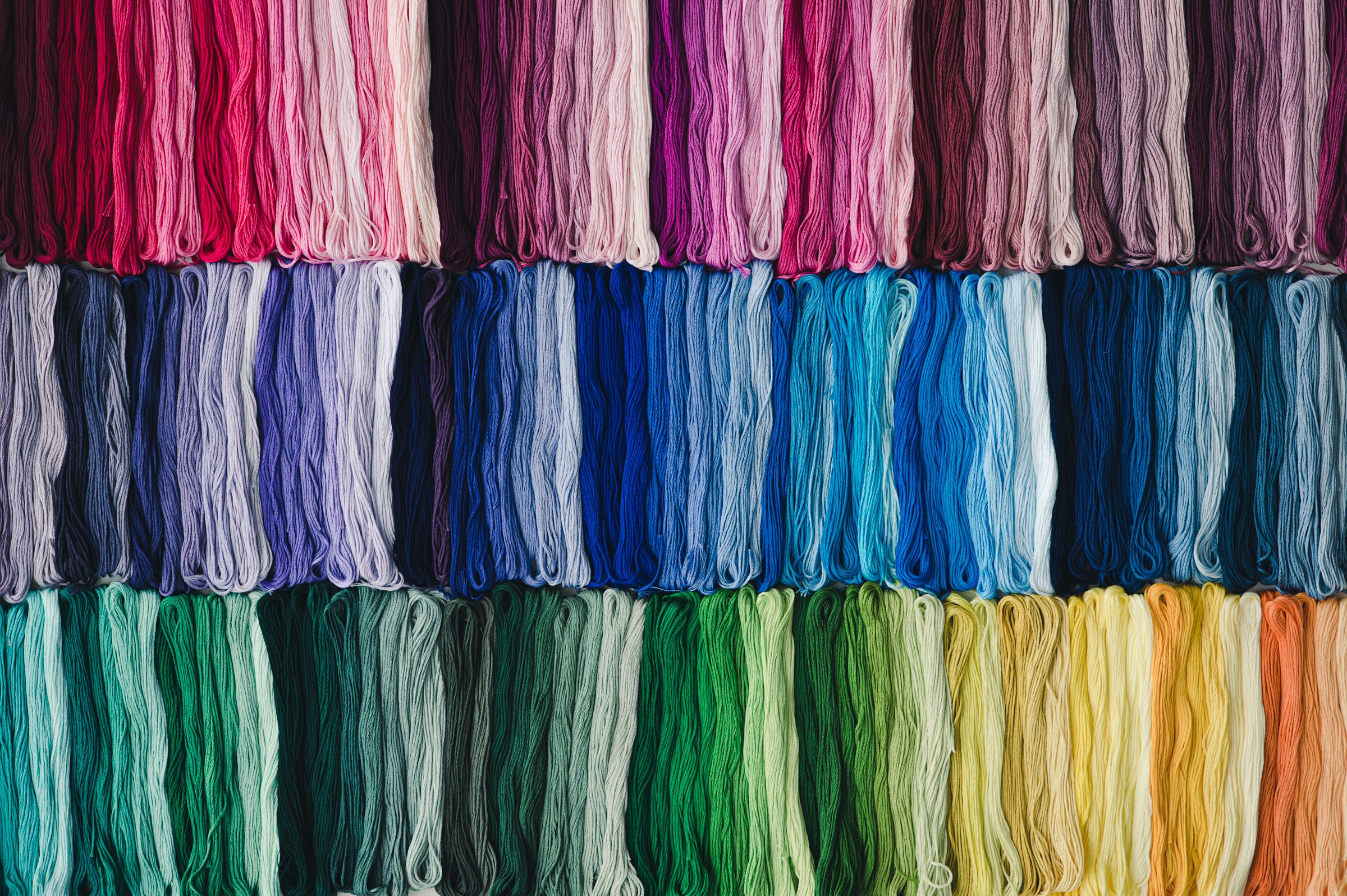 A wide arrangement of COSMO No. 25 embroidery floss skeins across over 500 solid colors