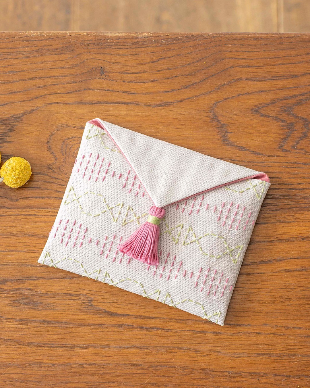 Sashiko pouches and mini totes on a mustard chair with antique books